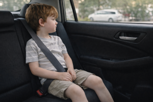 Child sitting calmly in the back seat of a car waiting before getting out